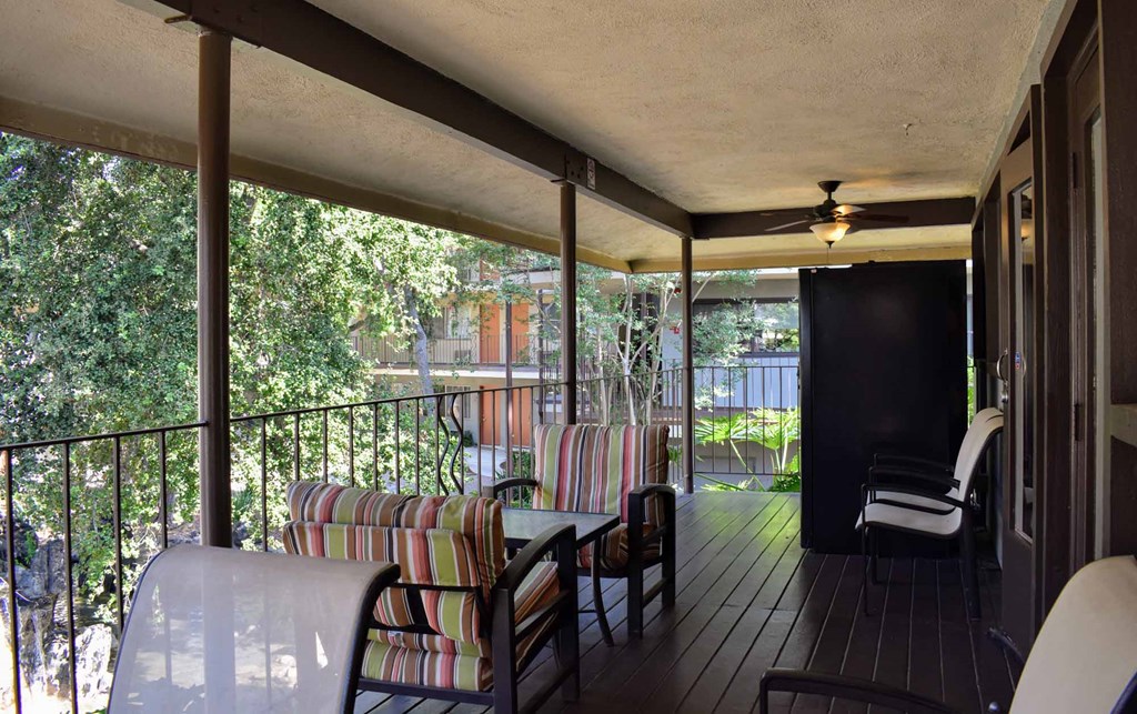 a covered porch with chairs and a table