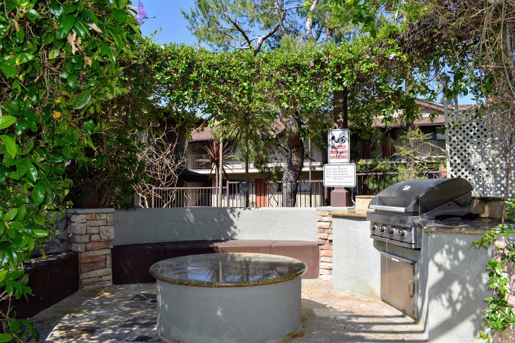 a backyard with a barbecue grill and a patio with a fountain