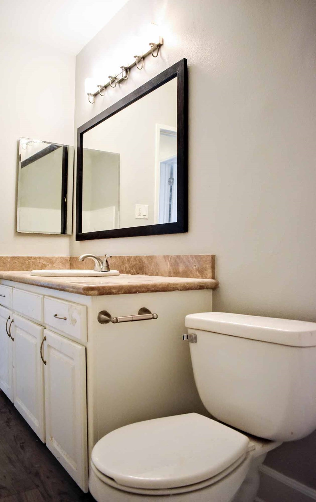 a bathroom with a toilet and a sink and a mirror