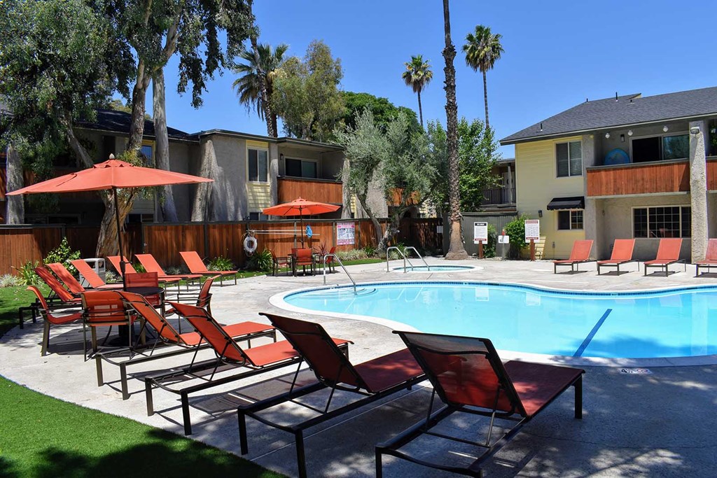 View from pool area with lounge chairs and seating area, and spa