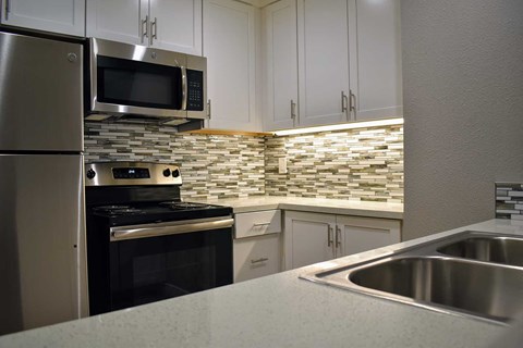 a kitchen with stainless steel appliances and white cabinets