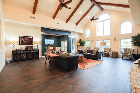 a large living room with leather furniture and a ceiling with exposed beams