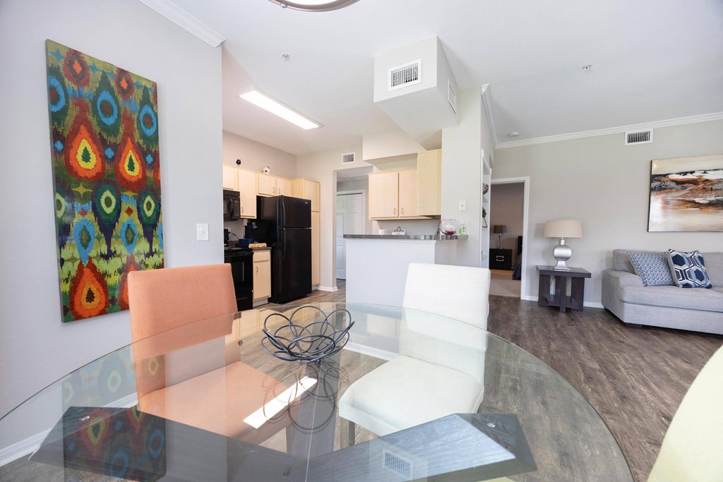 a living room and dining room with a glass table and chairs