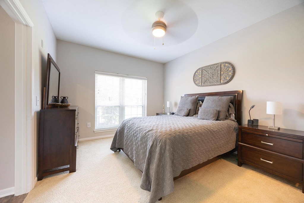 a bedroom with a bed and a dresser and a window
