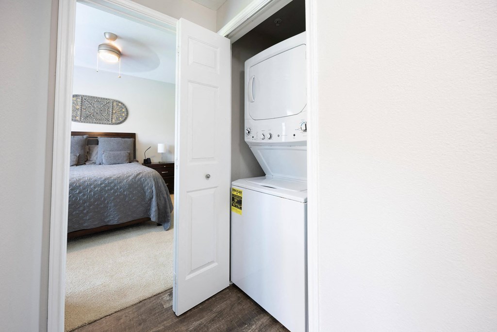 a small laundry room with a washer and dryer in a bedroom