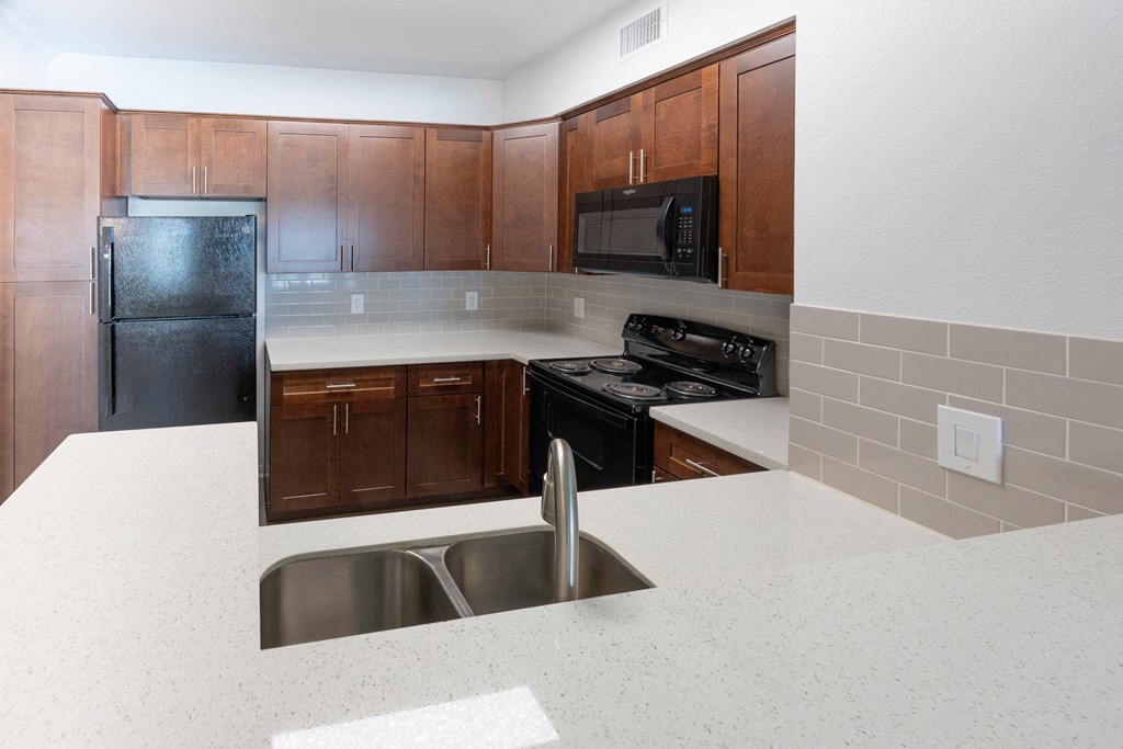 a kitchen with wooden cabinets and black appliances