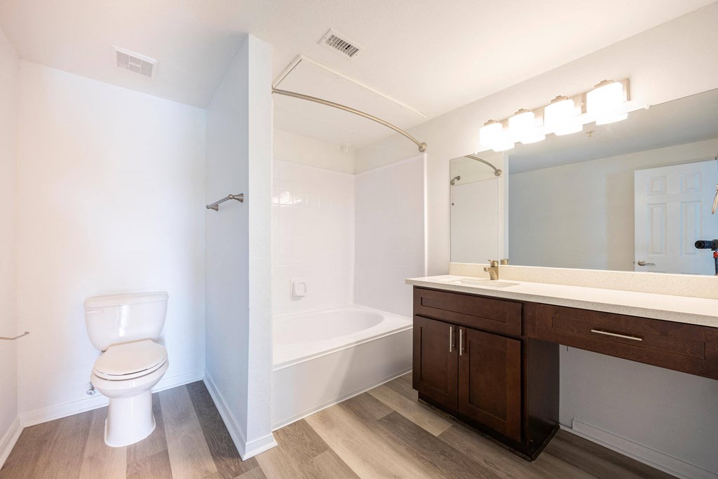 a bathroom with a toilet sink and tub and a mirror