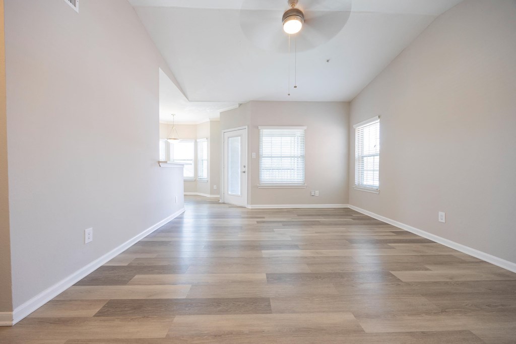 an empty living room with white walls and wood floors