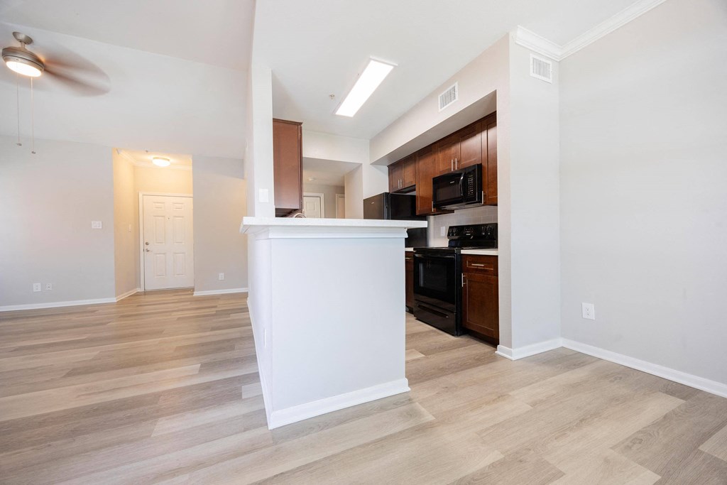 a kitchen and living room with a white counter top and
