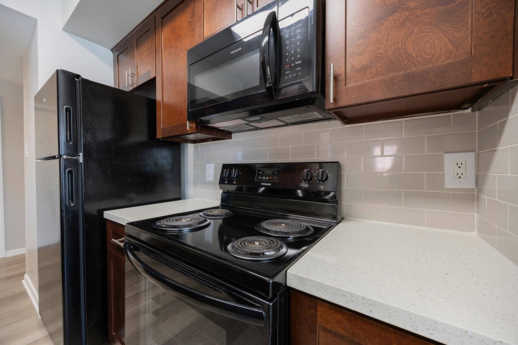 a kitchen with a stove and microwave and a refrigerator