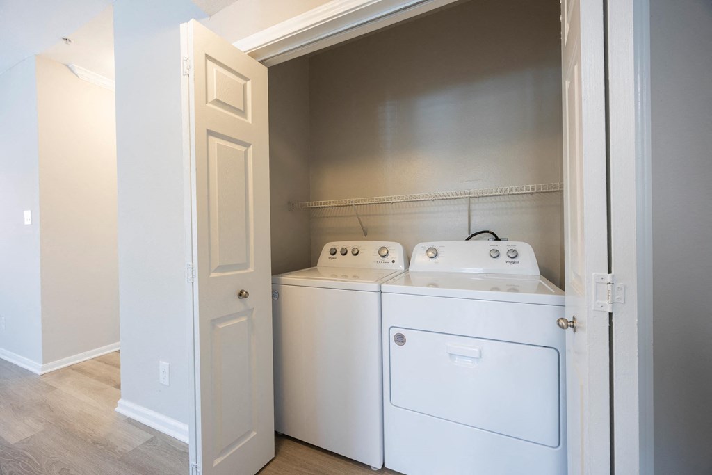 a white washer and dryer in a room with a door