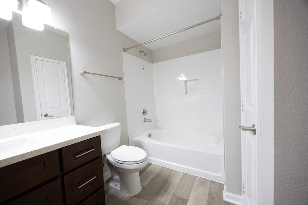 a bathroom with a toilet and a tub and a sink