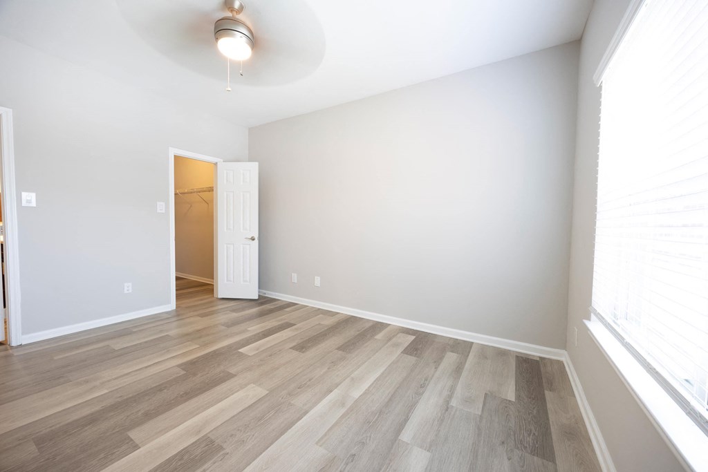 an empty room with wood flooring and a door to a closet