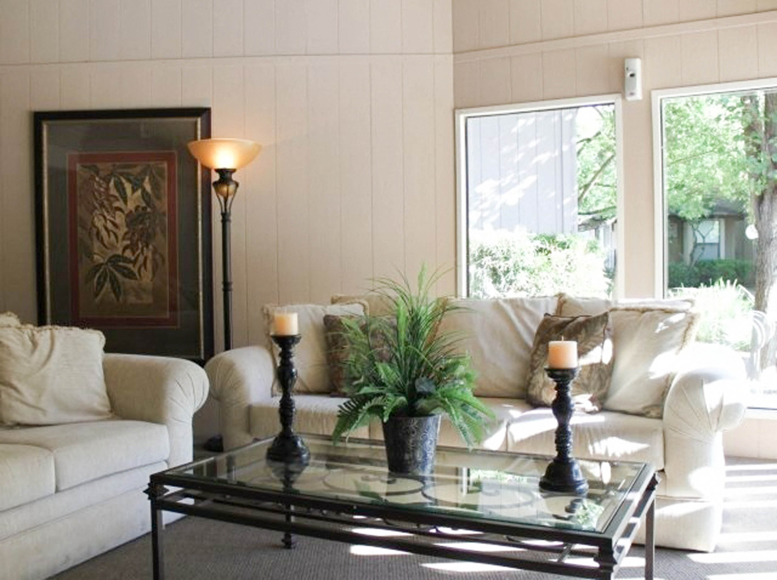 a living room with white furniture and a glass table
