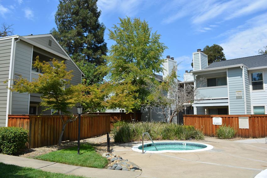 View of community spa, lush shrubbery, private patio/ balcony and exterior of buildings - Photo Gallery