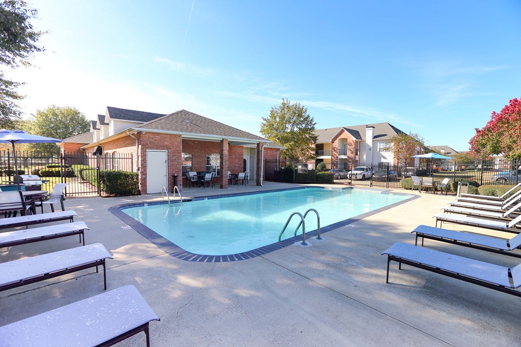 View of gated pool area with ample lounge chairs and sitting areas