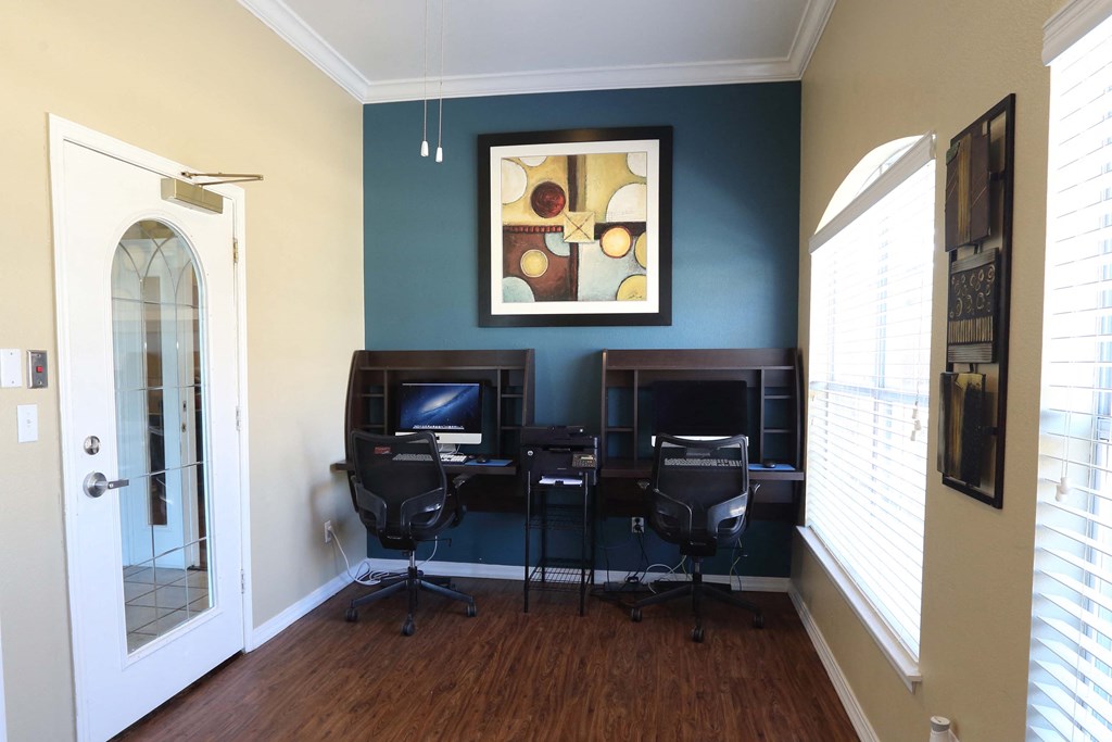 View of resident business center featuring two mac computers and sitting room with well lit windows and print copy fax machine