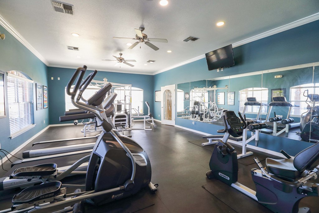 View of fitness center with weight machines, treadmill, stair stepper, stationary bike
