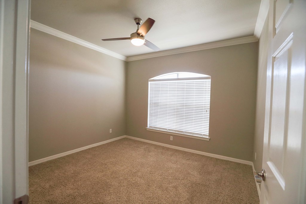View of bedroom with carpet floors, ceiling fan, and well lit window
