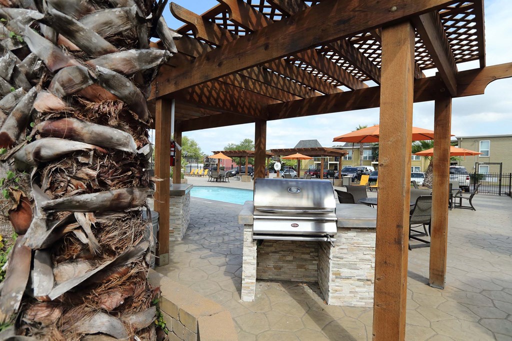 A wooden pergola with a grill underneath it at Willow Creek Apartments, Houston, Texas