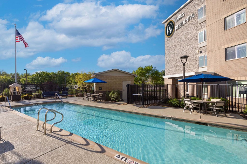 our apartments have a swimming pool and outdoor furniture  at Parks Residential - Richardson, Texas