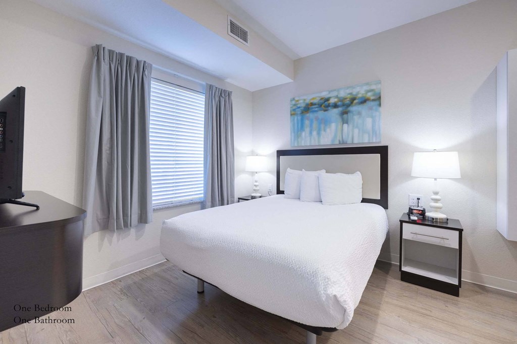 a bedroom with a white bed and a tv at Parks Residential - Richardson, Richardson, Texas