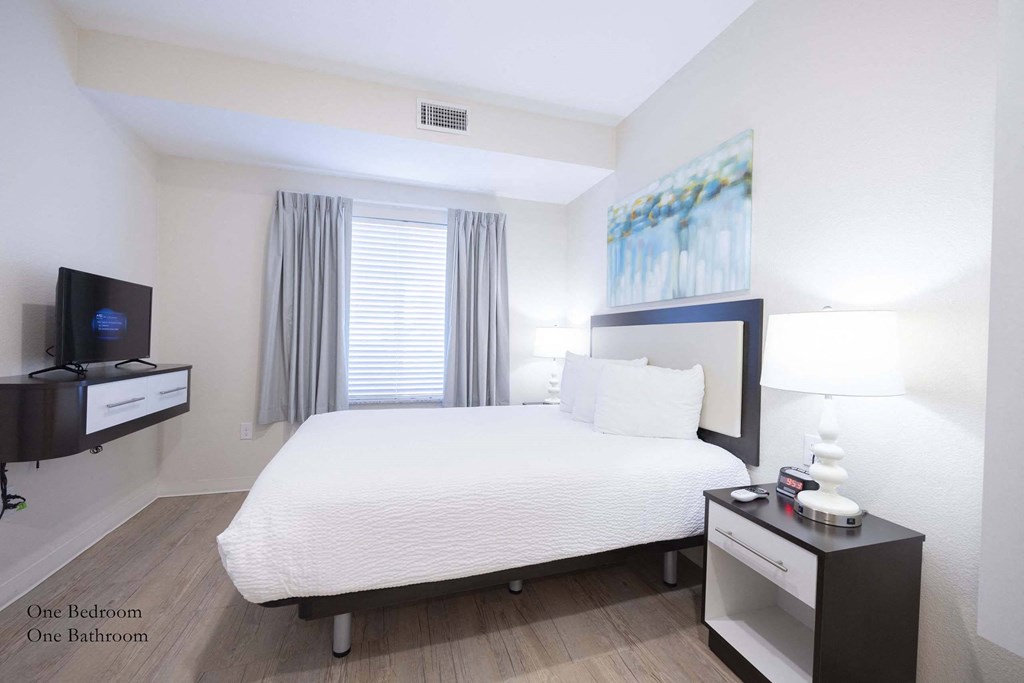 a bedroom with a large bed and a tv at Parks Residential - Richardson, Richardson, Texas