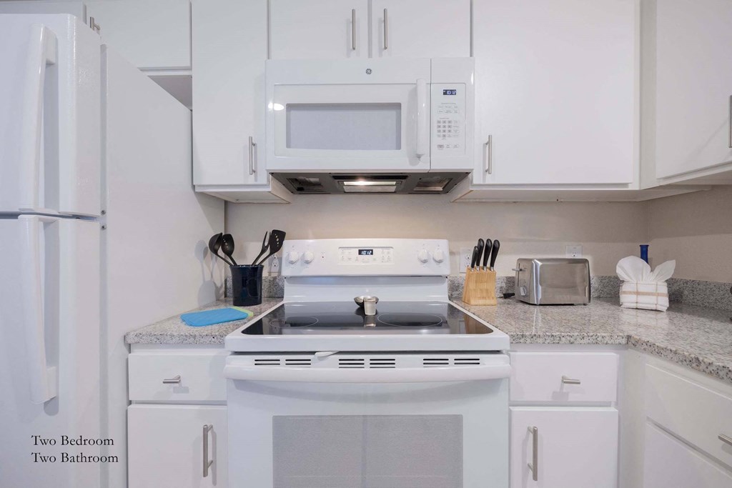 a kitchen with white appliances and white cabinets at Parks Residential - Richardson, Richardson, 75082