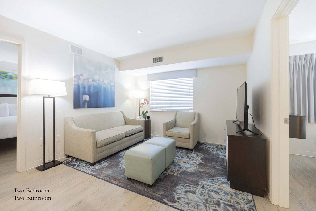 a living room with a couch and two chairs and a television at Parks Residential - Richardson, Texas