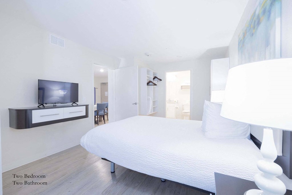 a bedroom with a large bed and a tv at Parks Residential - Richardson, Richardson, Texas