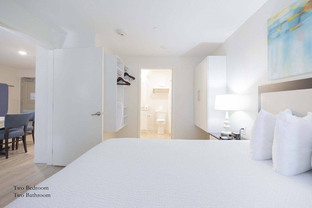 a bedroom with a large bed and a bathroom  at Parks Residential - Richardson, Richardson, TX, 75082