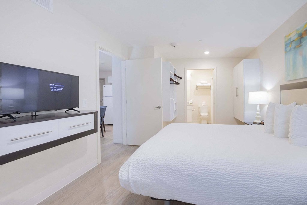 a bedroom with a large bed and a tv at Parks Residential - Richardson, Richardson, Texas