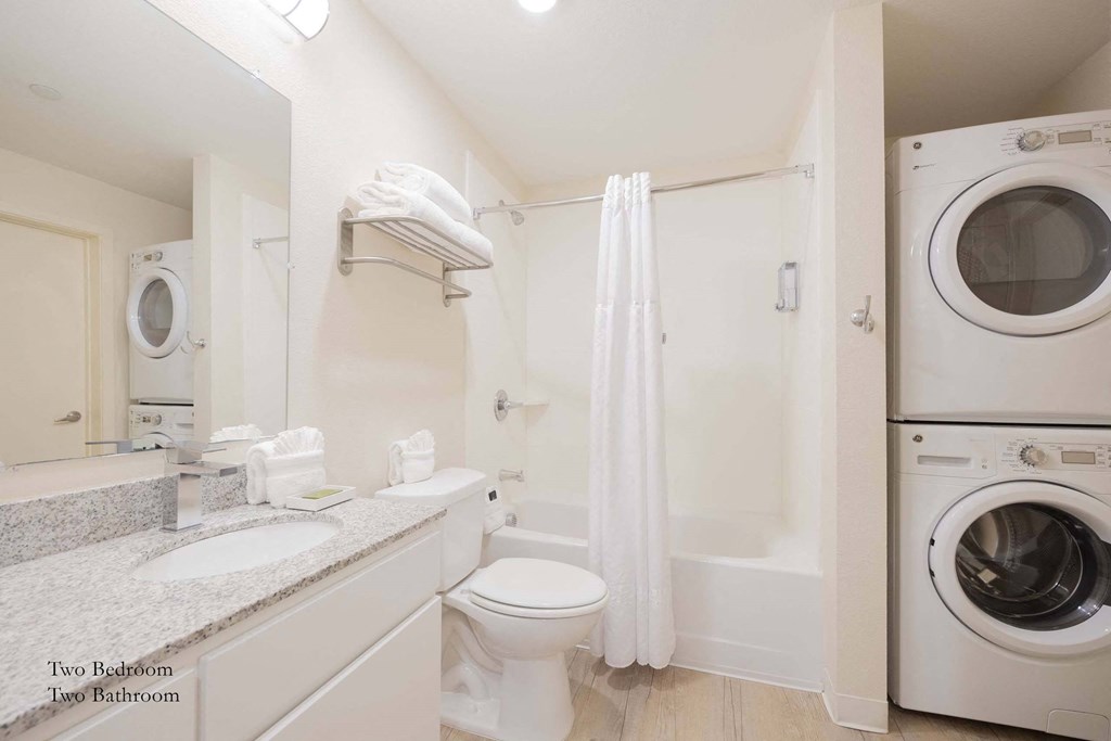 a bathroom with a washing machine and a toilet and a washer and dryer at Parks Residential - Richardson, Texas, 75082