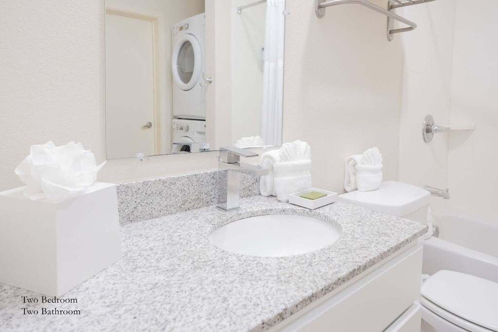 a white bathroom with a sink and a mirror at Parks Residential - Richardson, Texas
