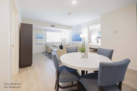 a living room and dining room with a white table and chairs at Parks Residential - Richardson, Texas, 75082