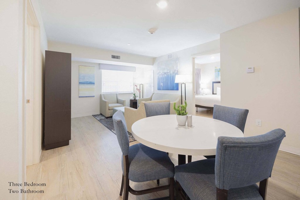 a living room and dining room with a white table and chairs a living room and dining room with a white table and chairs at Parks Residential - Richardson, Texas, 75082
