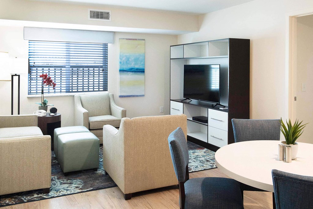 a living room with chairs and a table and a television at Parks Residential - Denver, Centennial, 80111