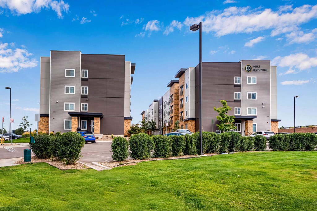 an exterior view of an apartment building with a parking lot at Parks Residential - Denver, Centennial, CO