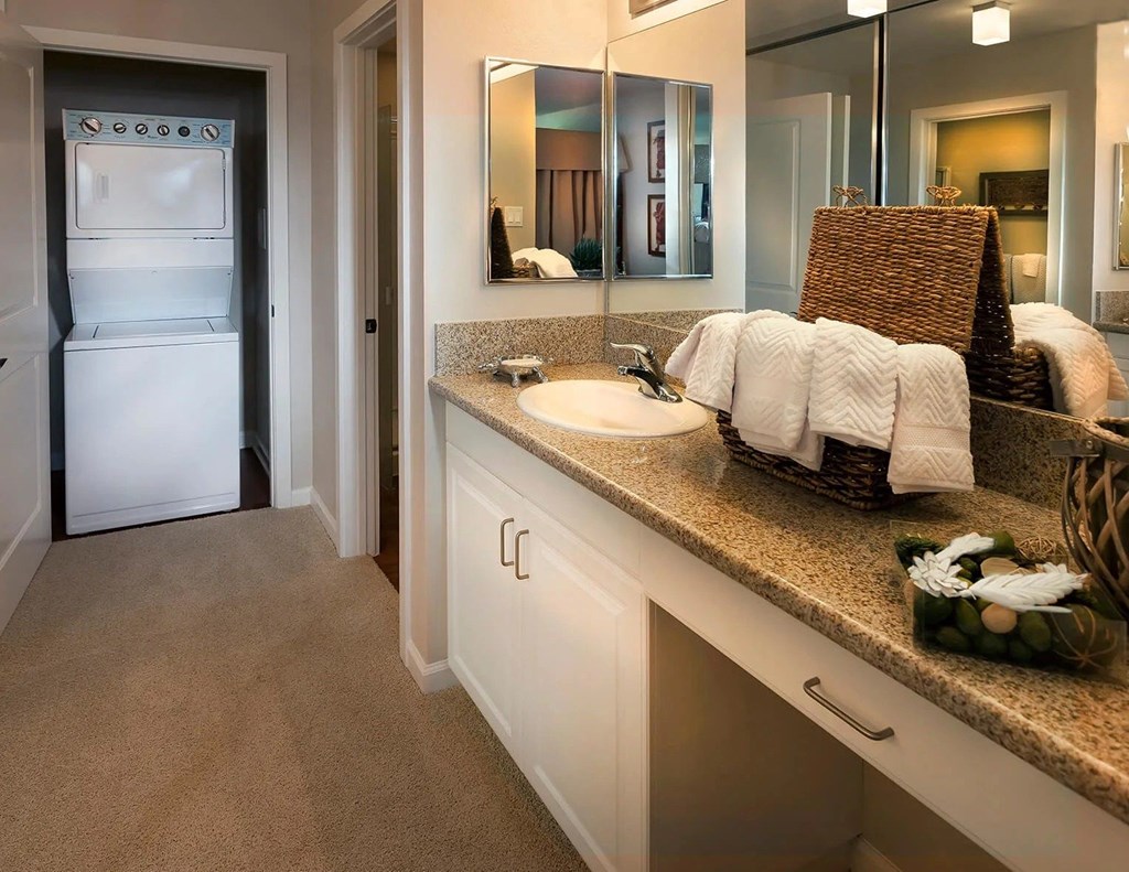A bathroom with a white sink and a white refrigerator.