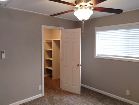 a bedroom with a ceiling fan and a closet