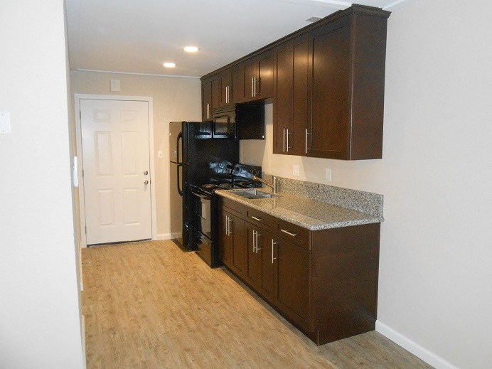 a kitchen with a black stove and a refrigerator