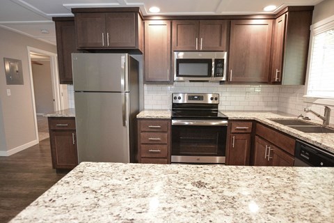 a kitchen with stainless steel appliances and marble counter tops