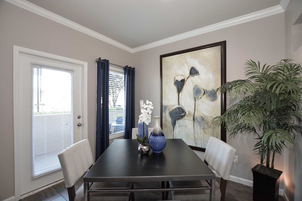 a dining room with a table and chairs and a painting on the wall