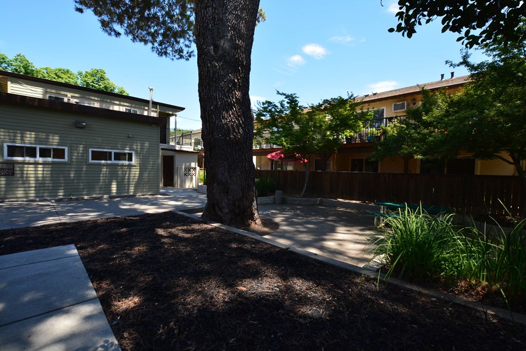 View of courtyard with picnic table and private patio/balcony in the background
