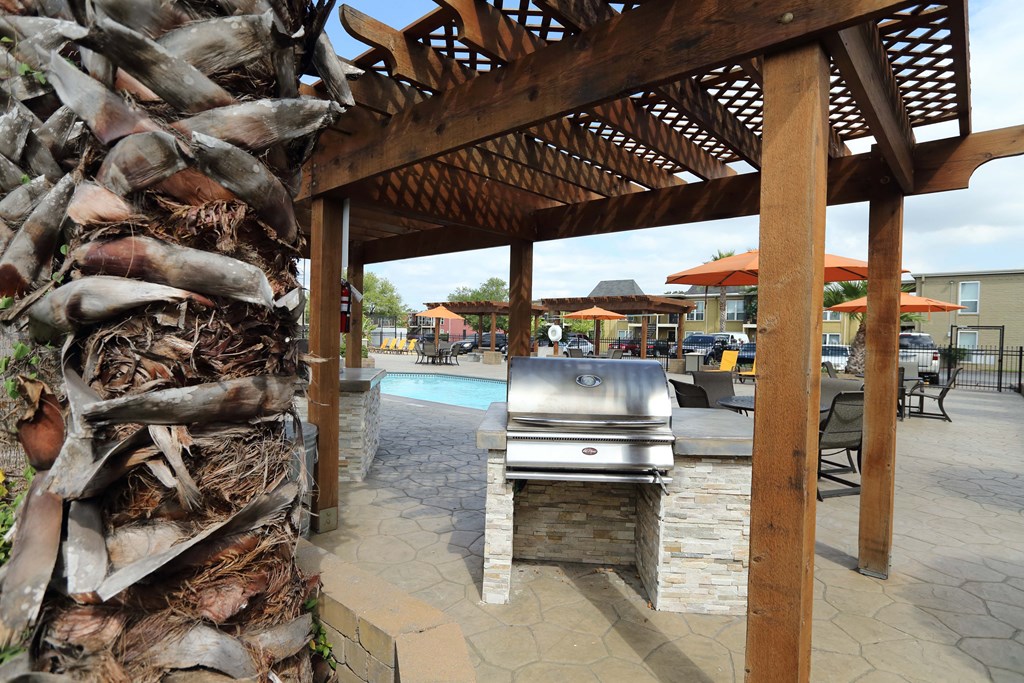 a grill is under a gazebo next to a pool