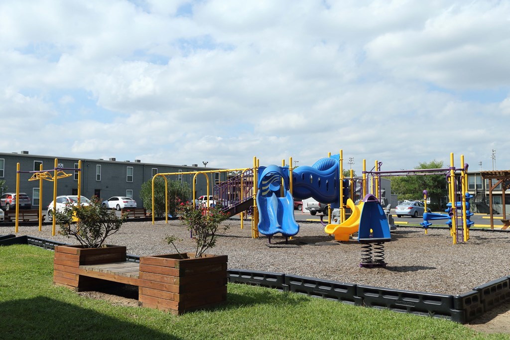 a playground with a blue and yellow swing set and other playground equipment