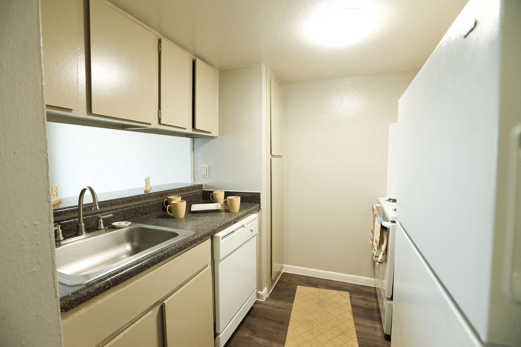 a kitchen with white cabinets and a sink and a refrigerator