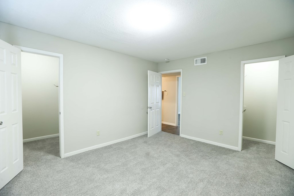 an empty room with white doors and a carpeted floor