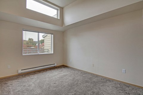 A room with a window and a view of a building outside.