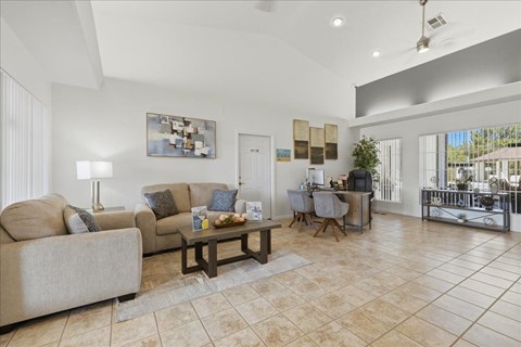 A living room with a couch, a coffee table, and a painting on the wall.